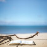 Buch im Sand mit Ausblick auf den Strand